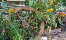 Декоративное колесо от тележки отлично украсит участок в деревенском стиле